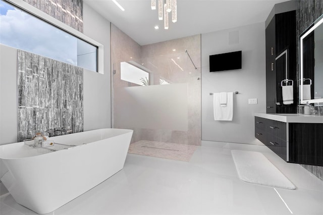 bathroom with walk in shower, a freestanding bath, and vanity