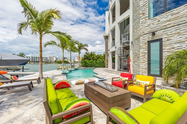 pool featuring a patio area, a water view, an outdoor living space, and stairs