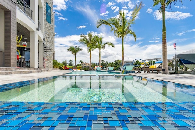 pool with a water play area and a patio