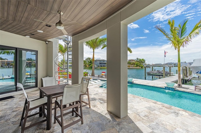 view of patio / terrace featuring an outdoor pool, a ceiling fan, boat lift, a water view, and a dock