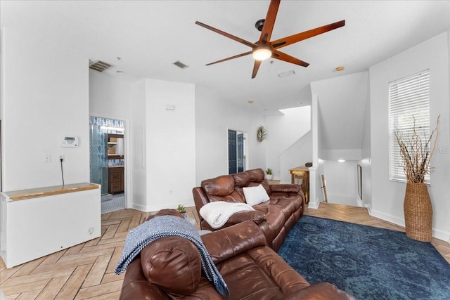 living area featuring baseboards, visible vents, and ceiling fan