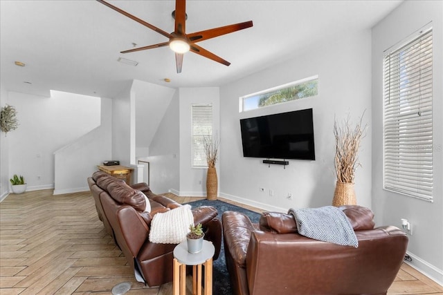 living area featuring ceiling fan and baseboards