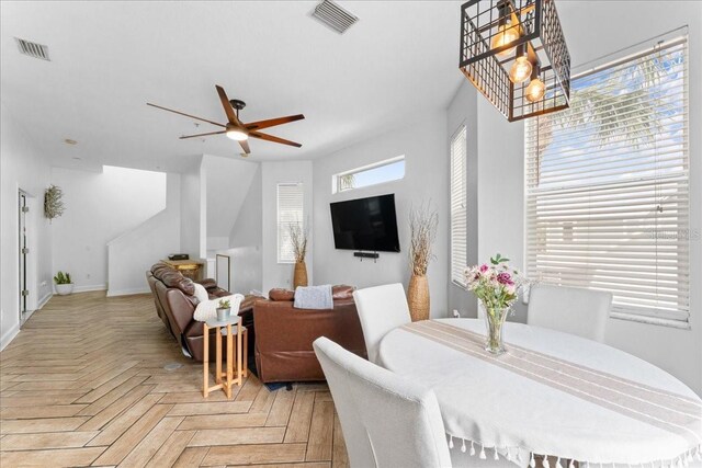 dining room with visible vents and ceiling fan with notable chandelier