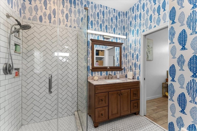 bathroom featuring wallpapered walls, a shower stall, vanity, and tile patterned floors