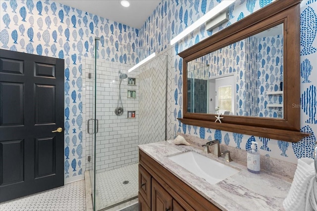 full bath with a stall shower, tile patterned floors, vanity, and wallpapered walls