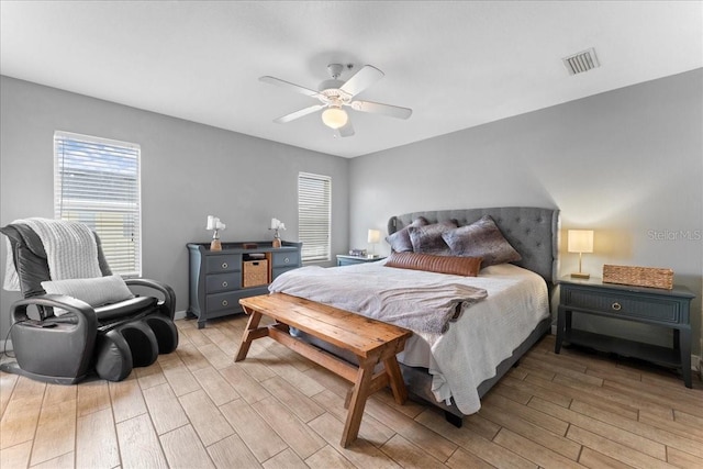 bedroom featuring light wood-style flooring, visible vents, and a ceiling fan