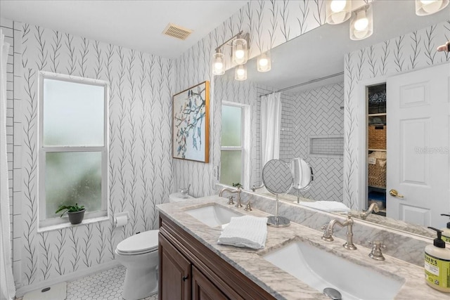 full bathroom featuring a shower with shower curtain, a sink, toilet, and wallpapered walls