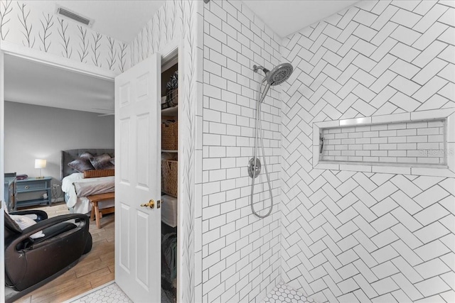 full bath with visible vents, a tile shower, and ensuite bath