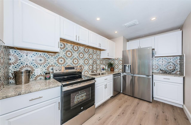 kitchen featuring stainless steel appliances, visible vents, a sink, and white cabinetry