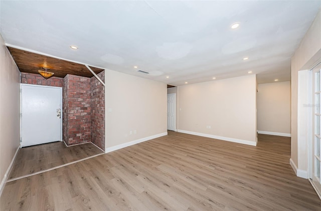 empty room with recessed lighting, wood finished floors, and baseboards