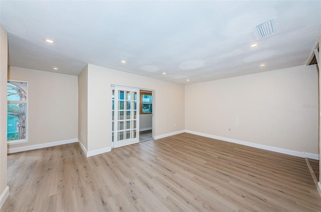 spare room with visible vents, light wood finished floors, and baseboards