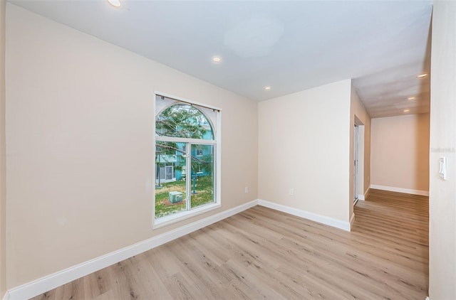 unfurnished room with light wood-style floors, recessed lighting, and baseboards