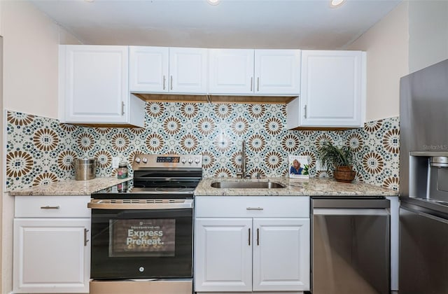 kitchen with appliances with stainless steel finishes, white cabinets, and a sink