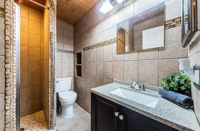 bathroom featuring tiled shower, toilet, wooden ceiling, vanity, and tile walls