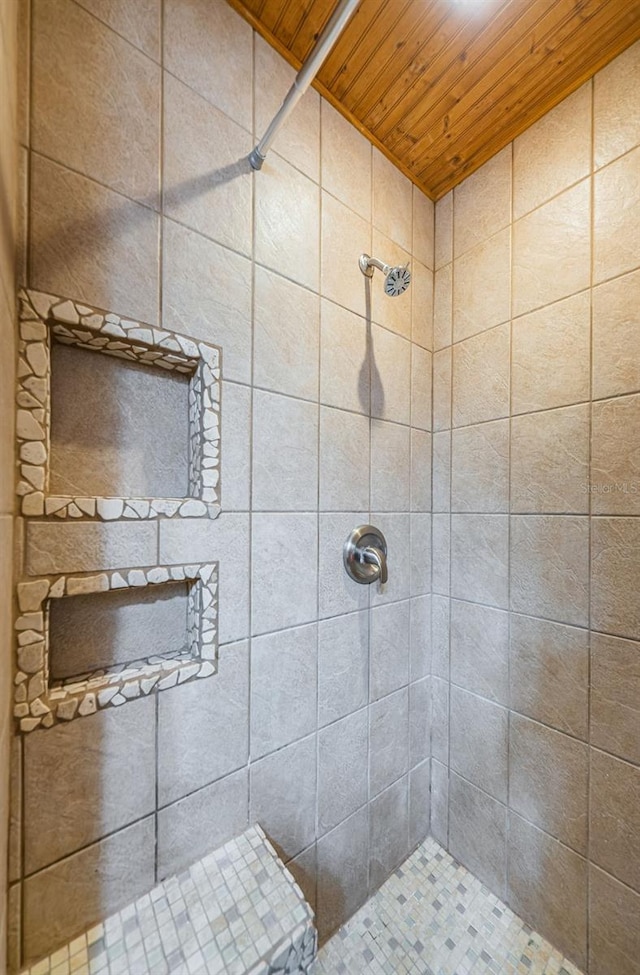 bathroom featuring wood ceiling and a tile shower