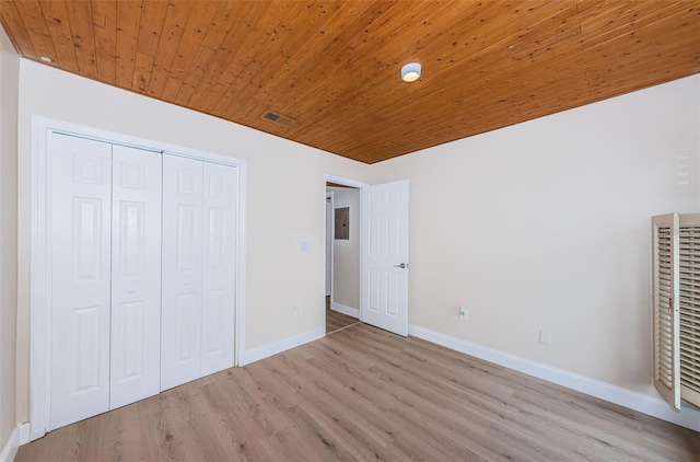 unfurnished bedroom featuring wooden ceiling, wood finished floors, visible vents, baseboards, and a closet