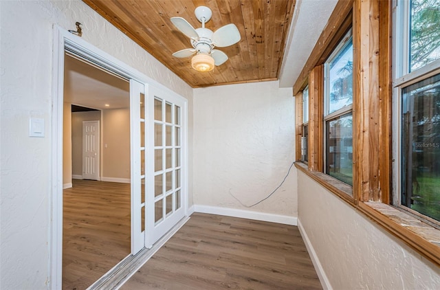 unfurnished sunroom with french doors, wooden ceiling, and a ceiling fan