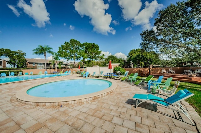 community pool featuring fence and a patio