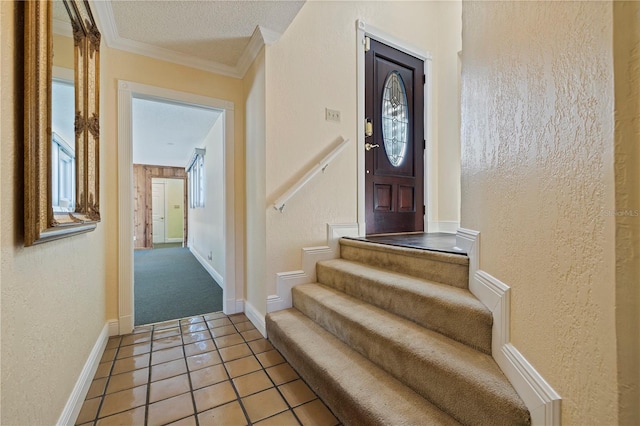 interior space featuring baseboards, a textured wall, tile patterned floors, a textured ceiling, and crown molding