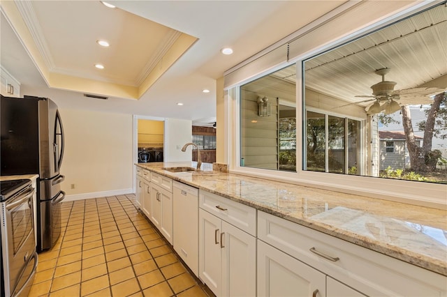 kitchen with white dishwasher, washing machine and dryer, a sink, stainless steel electric stove, and a tray ceiling