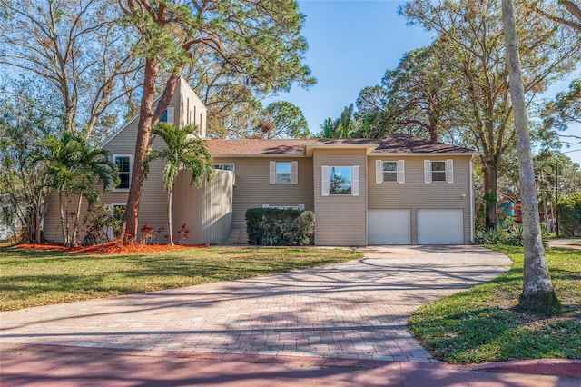 view of front of house with an attached garage, decorative driveway, and a front yard