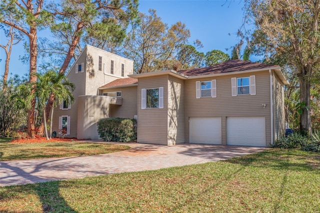 view of front of home featuring a garage, a front yard, and decorative driveway