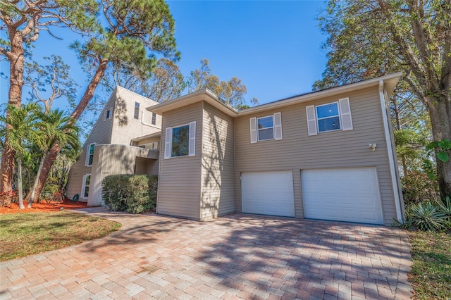 view of front facade with a garage and decorative driveway