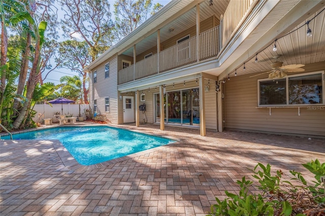 view of swimming pool featuring a patio area, fence, a fenced in pool, and a ceiling fan