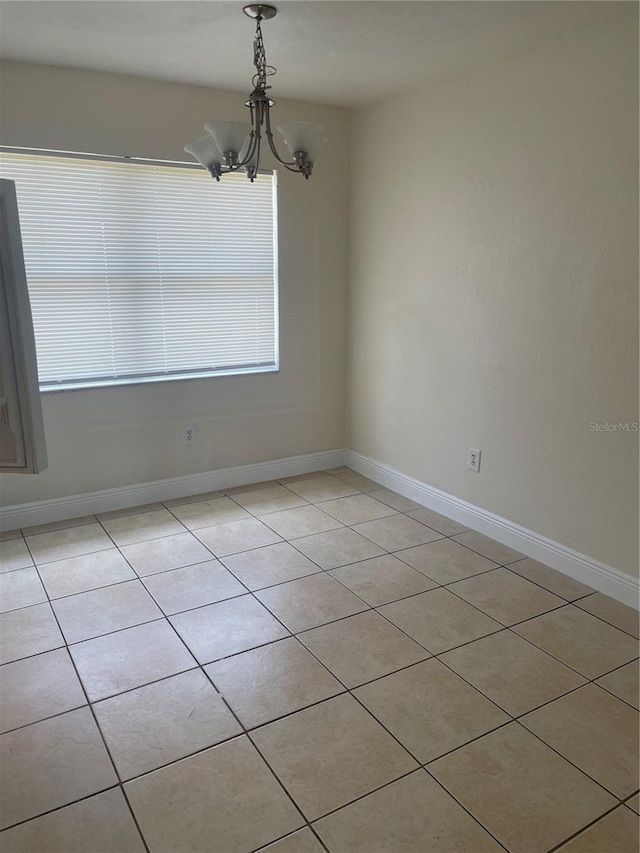 unfurnished dining area featuring plenty of natural light, a chandelier, and baseboards