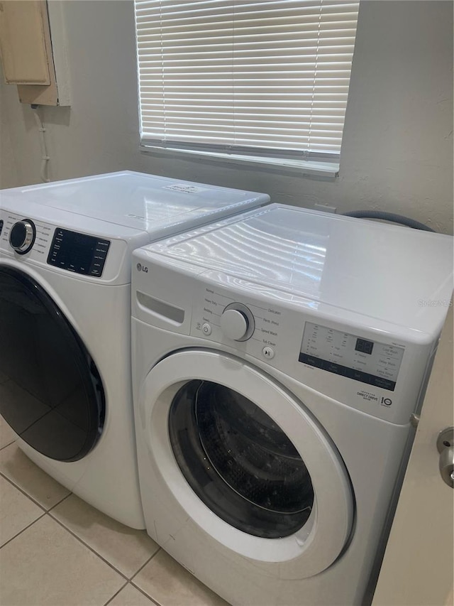 washroom featuring laundry area, light tile patterned floors, and washer and dryer