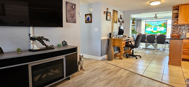 interior space with light wood-type flooring, a fireplace, and baseboards