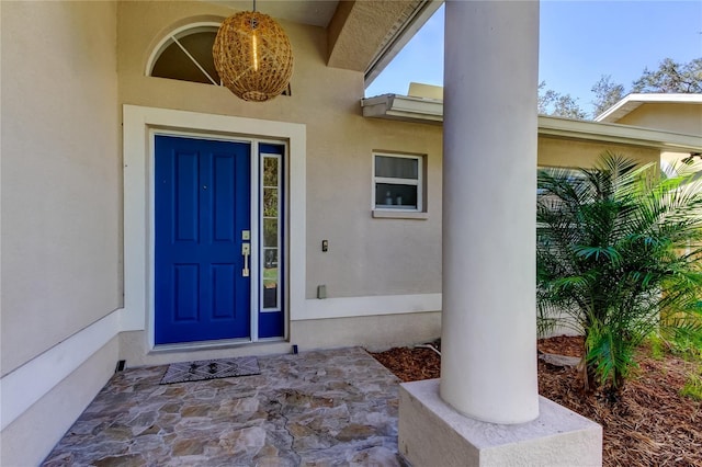 view of exterior entry featuring stucco siding