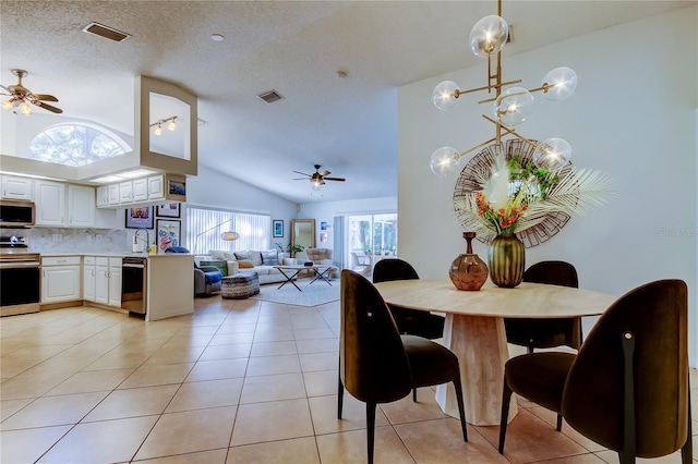 dining space with light tile patterned floors, visible vents, a textured ceiling, and ceiling fan