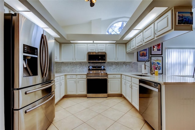 kitchen with light tile patterned floors, lofted ceiling, a sink, stainless steel appliances, and light countertops