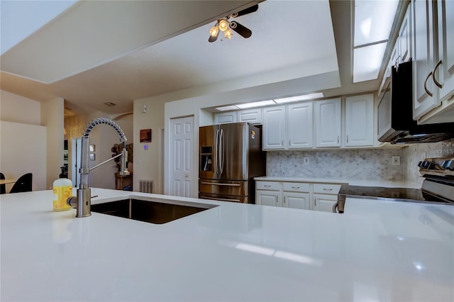 kitchen with backsplash, white cabinets, stainless steel appliances, and a sink