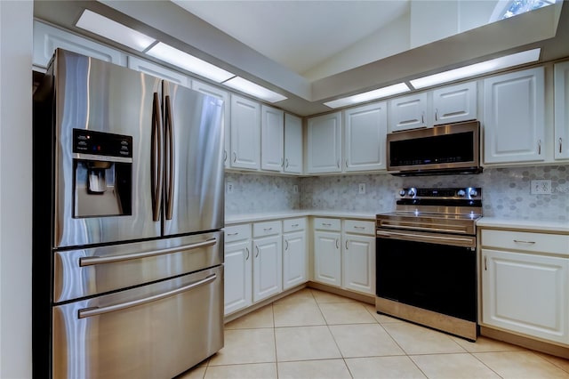 kitchen featuring light countertops, light tile patterned floors, decorative backsplash, white cabinets, and stainless steel appliances