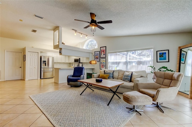 living room featuring light tile patterned flooring, visible vents, and lofted ceiling