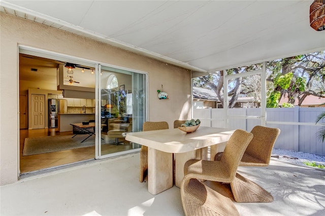 view of patio with a sink, outdoor dining area, and fence