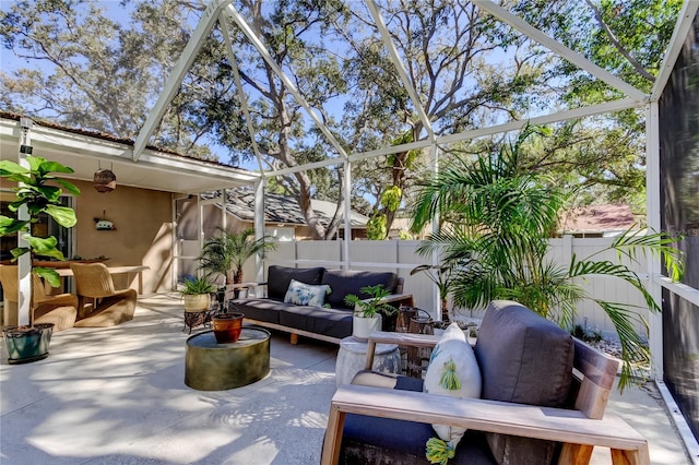 view of patio featuring an outdoor living space, glass enclosure, and a fenced backyard