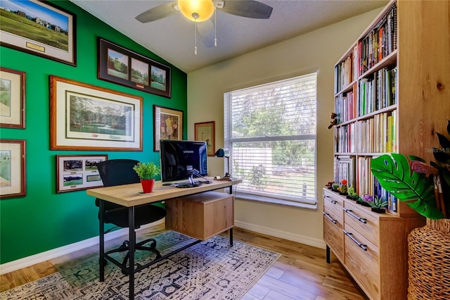 office space with baseboards, a ceiling fan, lofted ceiling, and wood finished floors