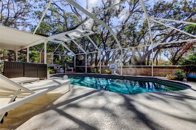 view of pool featuring glass enclosure, a patio area, a fenced in pool, and an outdoor hangout area