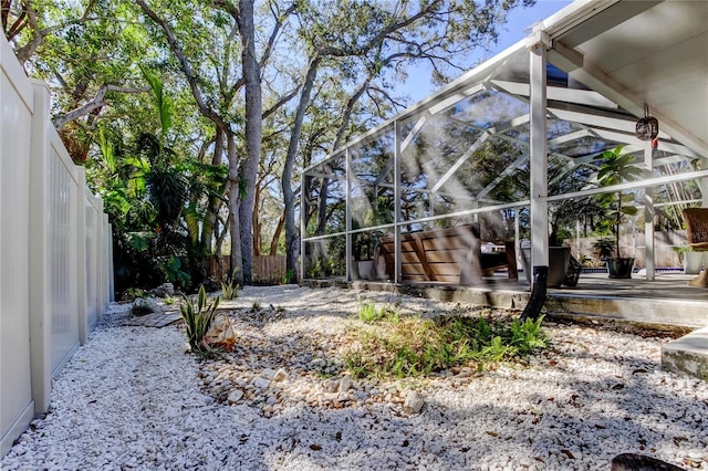 view of yard featuring glass enclosure, a patio area, and a fenced backyard