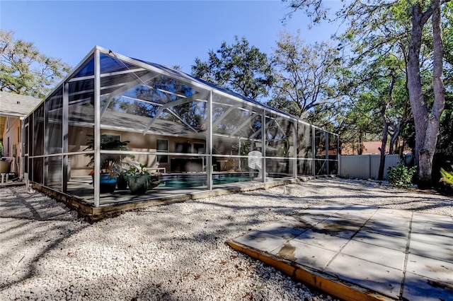 back of house with an outdoor pool, a lanai, a patio area, and fence