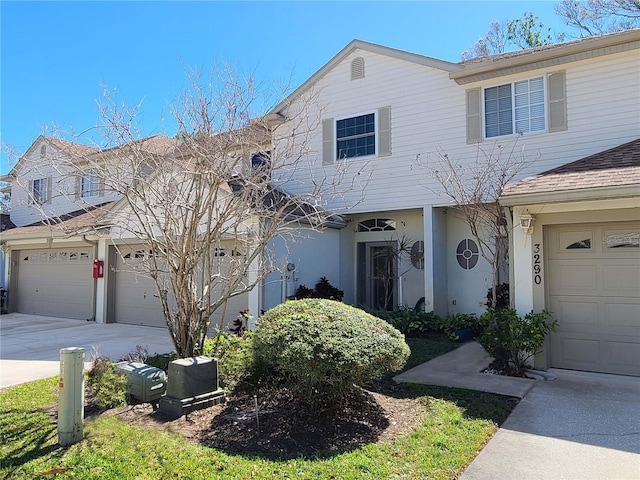 view of front of property featuring concrete driveway, an attached garage, and stucco siding