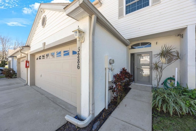 doorway to property featuring a garage and stucco siding