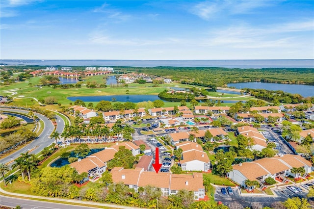 drone / aerial view with view of golf course, a water view, and a residential view