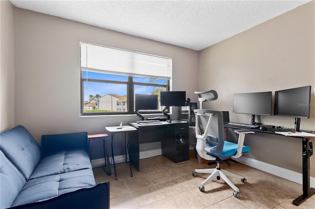 home office with light tile patterned flooring, a textured ceiling, and baseboards