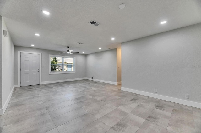 empty room featuring baseboards, visible vents, and recessed lighting