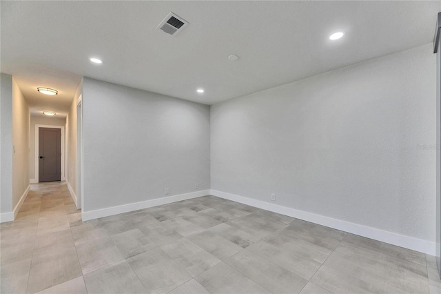 unfurnished room with baseboards, visible vents, and recessed lighting