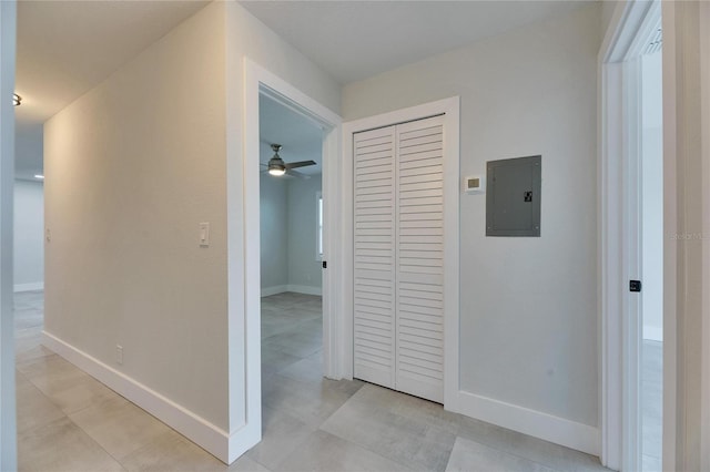 hall with electric panel and baseboards